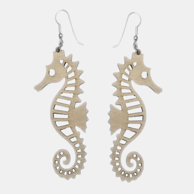 Set van twee lasergesneden houten zeepaardje oorbellen met zilverkleurige oorhaken, tegen een lichte achtergrond. Natuurlijke marine-sieraden.