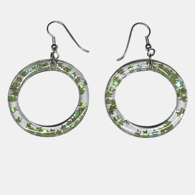 Handgemaakte transparante epoxy oorbellen met glanzende geel/groene sterretjes en zilverkleurige oorhaakjes.