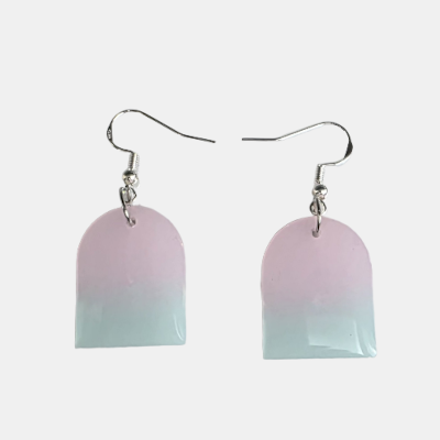 Handgemaakte resin oorbellen met een zacht kleurverloop van pastelroze naar mintgroen in een moderne boogvorm met zilverkleurige haakjes.