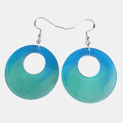 Handgemaakte ronde kunsthars oorbellen met een kleurverloop van oceaanblauw naar zeegroen en zilverkleurige haakjes.
