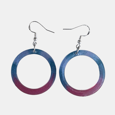 Handgemaakte ronde epoxy oorbellen met een sprankelend kleurverloop van blauw naar paars en zilveren haken.