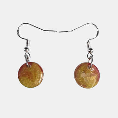Handgemaakte ronde hars oorbellen met een organisch goud en roze marmerpatroon aan zilverkleurige oorhaakjes.